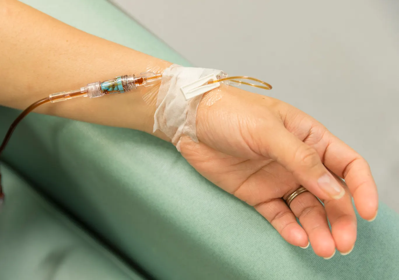 Kroplówki witaminowe Rypin: dłoń z wenflonem i linią infuzyjną na podkładzie